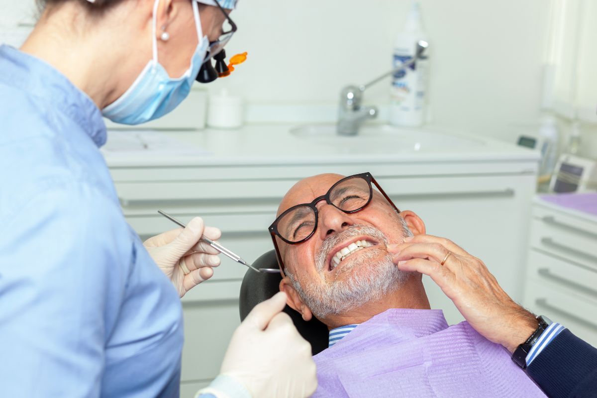 Senior man receiving dental exam from dentist in San Antonio office.